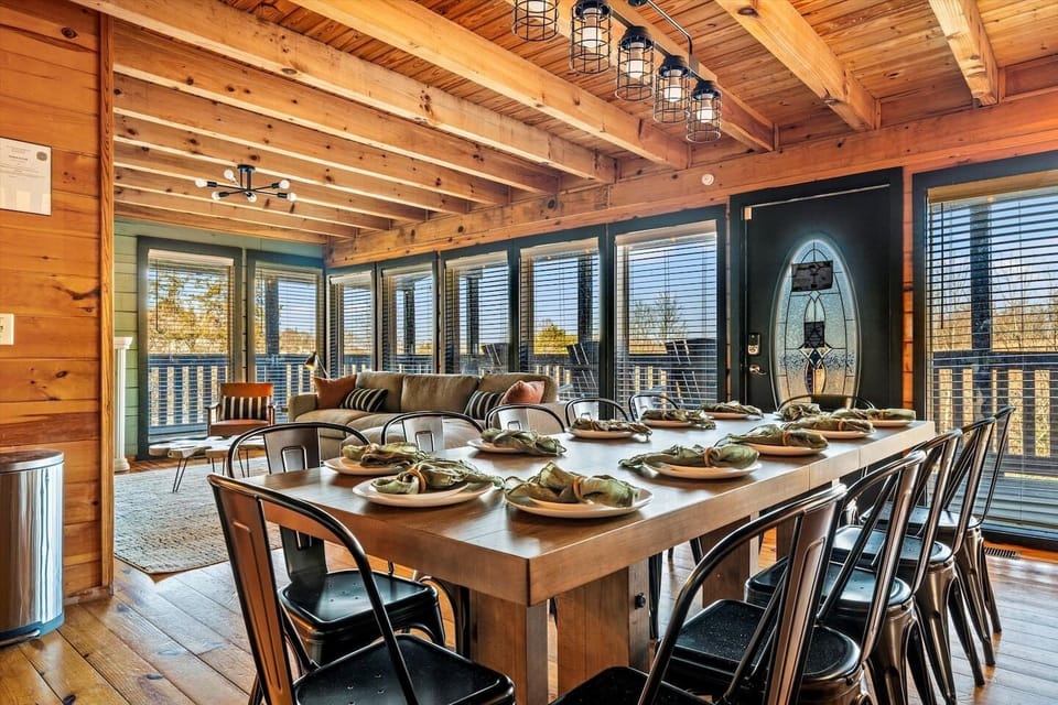 Host a family feast at the massive wooden dining table, a centerpiece of this Smoky Mountain cabin designed for long conversations and home-cooked meals after exploring the Parkway.