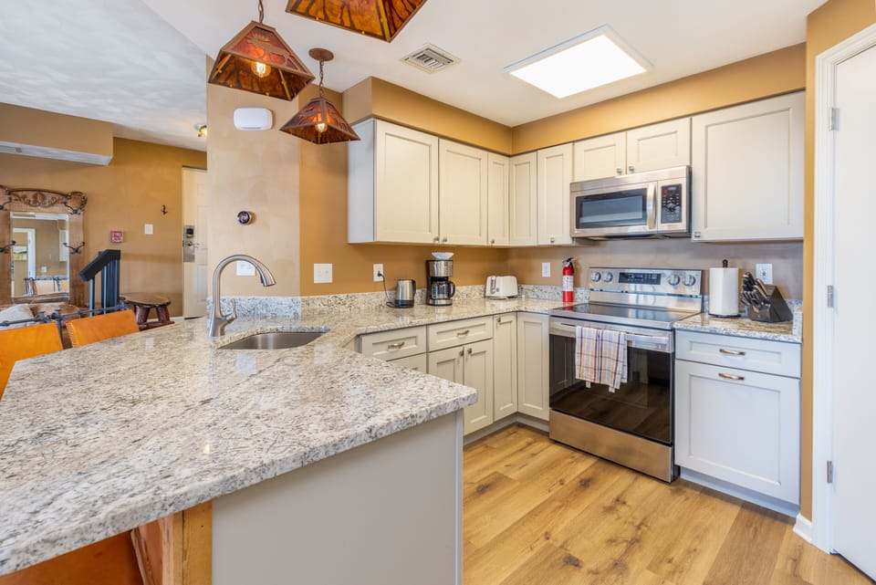 Well equipped kitchen with granite countertops and stainless steel appliances