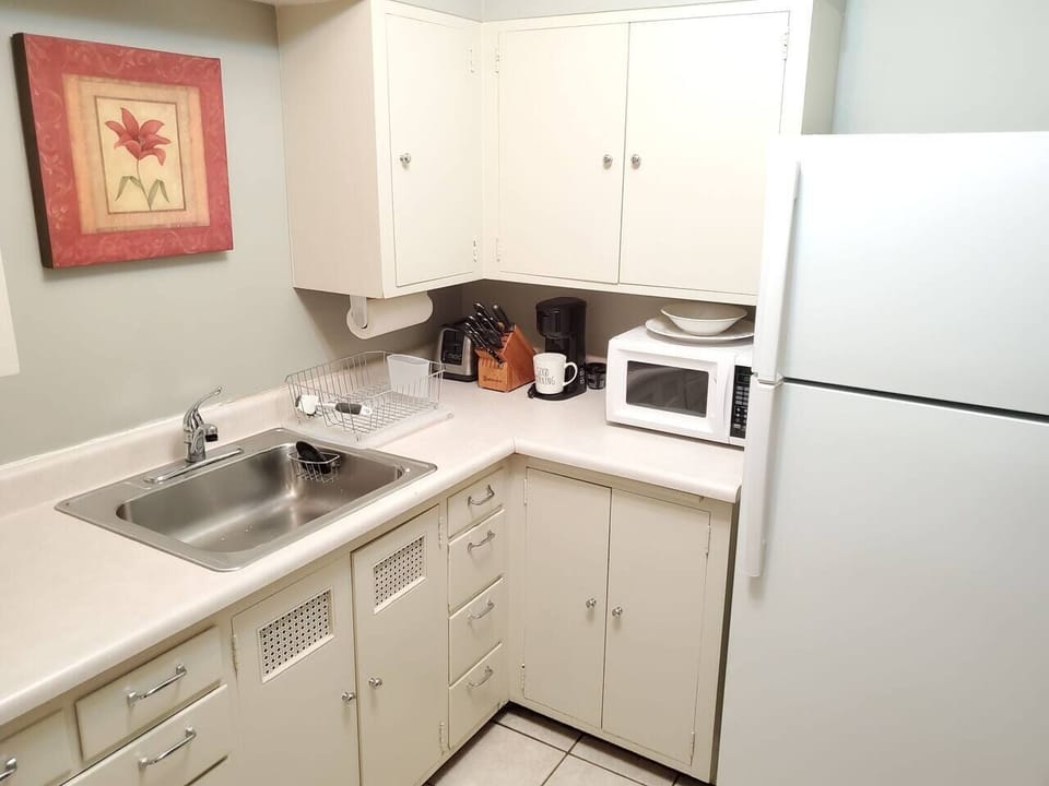Kitchen w/essentials, microwave, stove, oven, refrigerator, freezer, coffee machine