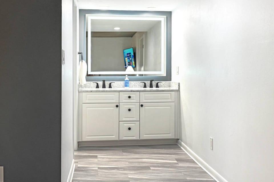 Get ready in style with this beautifully updated vanity featuring double sinks, a glowing LED mirror, and plenty of counter space