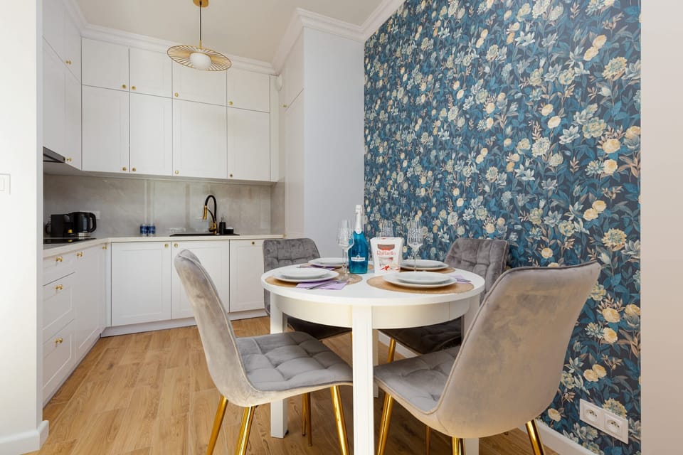 A dining space with patterned wallpaper, a round table, and upholstered chairs for a chic look.
