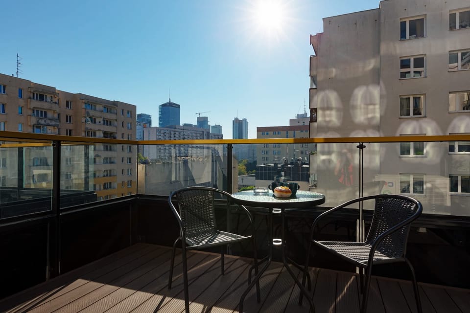 A private balcony with outdoor furniture and a cityscape view, perfect for relaxation.
