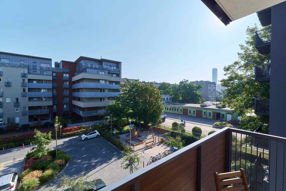 Another balcony perspective showing the view of neighboring modern residential buildings and greenery below.