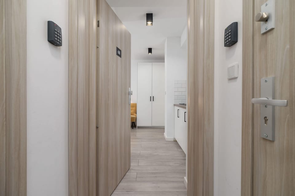A hallway with wooden doors and modern lighting leading to the rooms.

