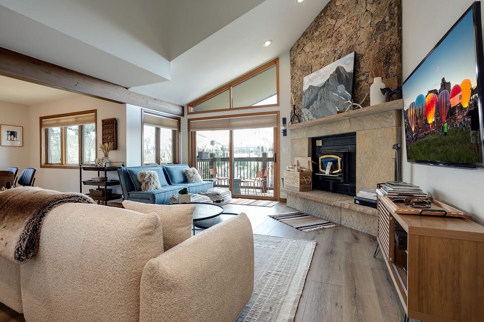 Sink into plush seating by your stone fireplace, let natural light pour through floor-to-ceiling windows, and enjoy soaring ceilings that make your alpine retreat feel open and inviting.