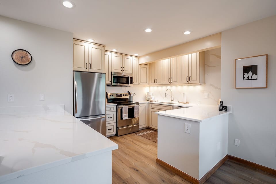 Your modern kitchen awaits with gleaming appliances, warm wood floors, and pristine counters perfect for preparing memorable meals.