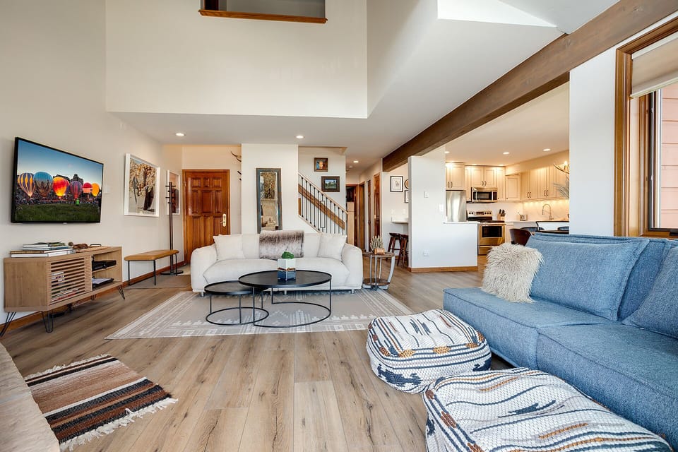 Unwind in this bright, open living space where modern comfort meets rustic charm with exposed beams and your fully equipped kitchen nearby.