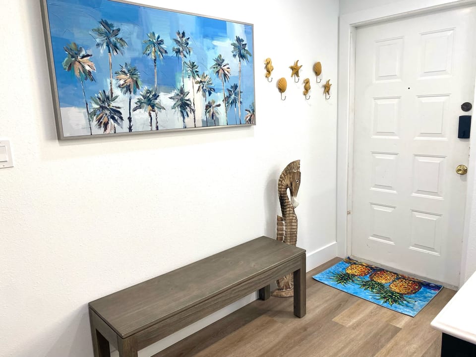 The entryway has a bench for shoes and hooks for *dry* towels