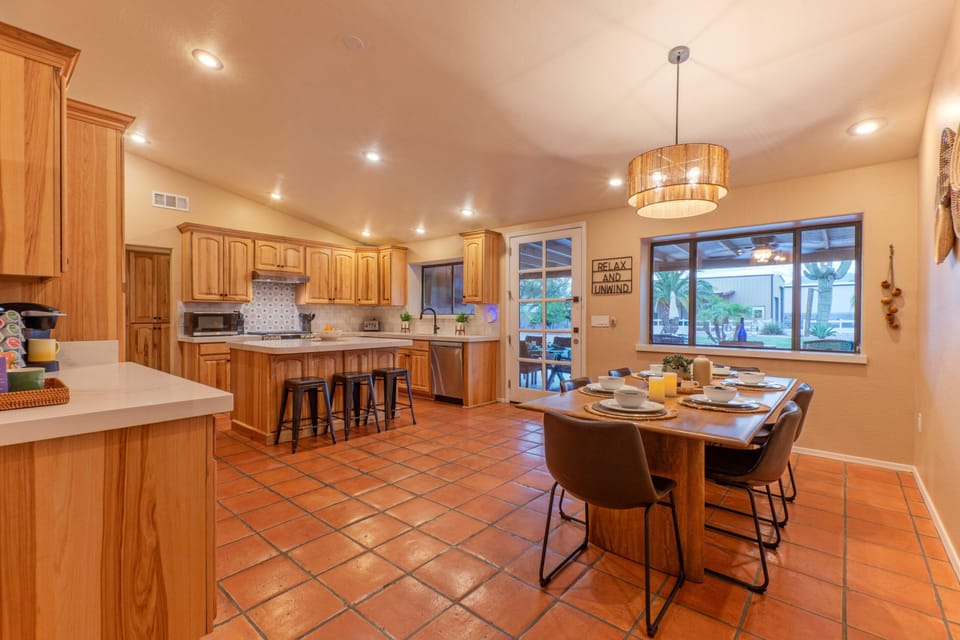 Modern and well stocked kitchen opens into a dining area with table seating.