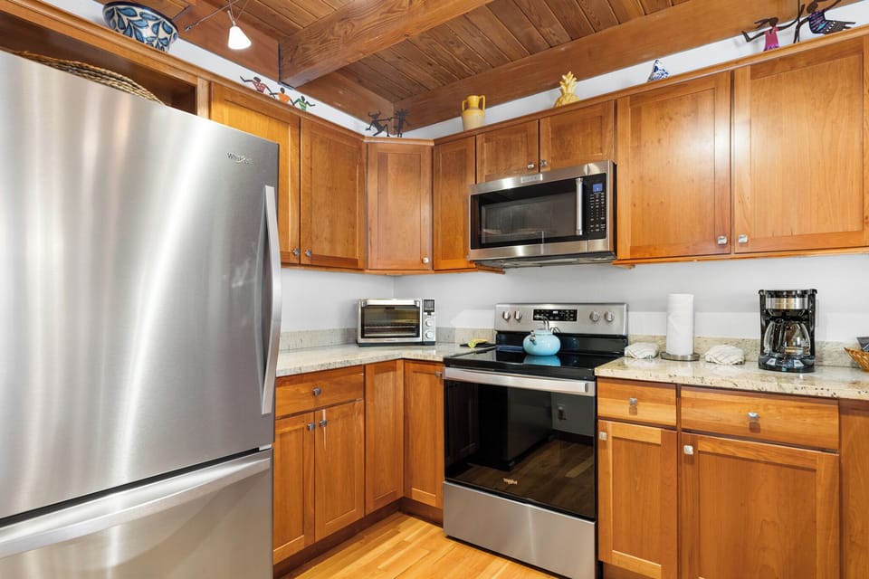 Your fully equipped kitchen features warm wood cabinets, granite counters, and stainless steel appliances—perfect for cooking memorable meals during your stay.