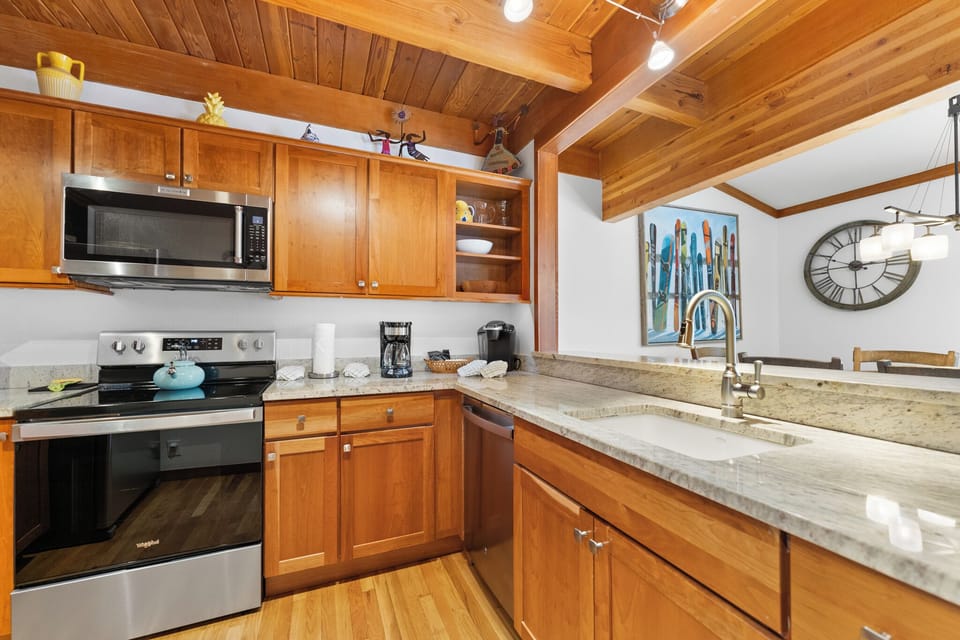 Your fully equipped kitchen features warm wood cabinets, granite counters, and exposed beams—perfect for preparing meals in mountain style.
