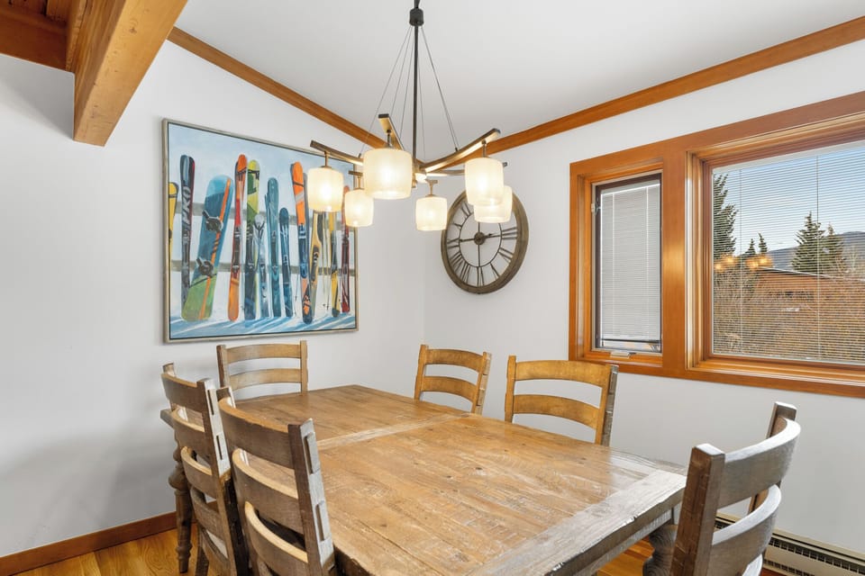 Gather around this rustic dining table where warm wood beams frame your mountain meals and ski memories decorate the walls.