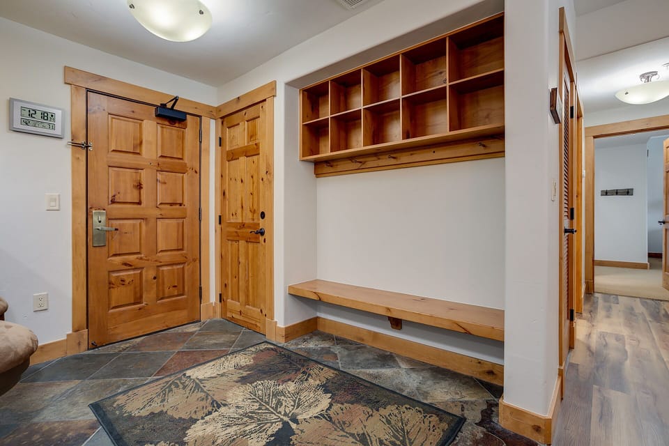 Step into your cozy entryway with custom wooden storage cubbies and bench, perfect for organizing your gear after mountain adventures.
