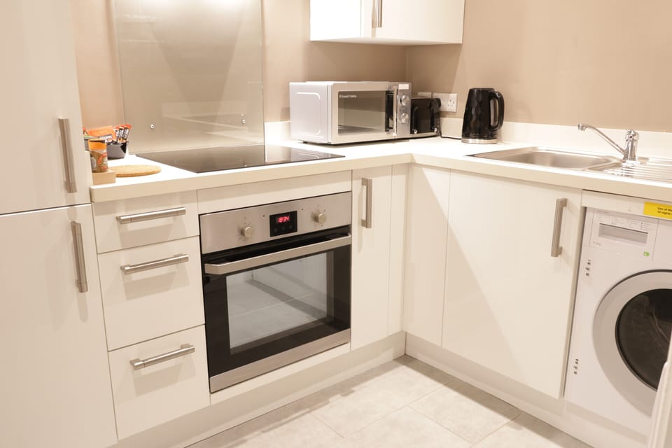 Fully equipped kitchen with electric oven, hob, microwave, kettle, toaster.