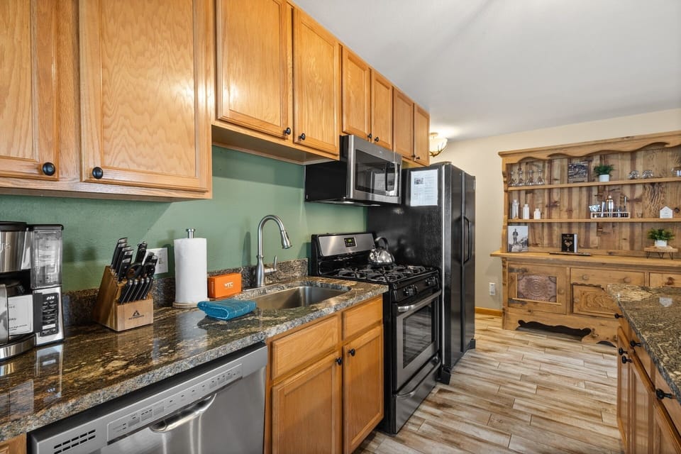 Kitchen side view - Spacious open floor plan kitchen with island bar, gas range, basin sink, microwave and drip coffee maker.