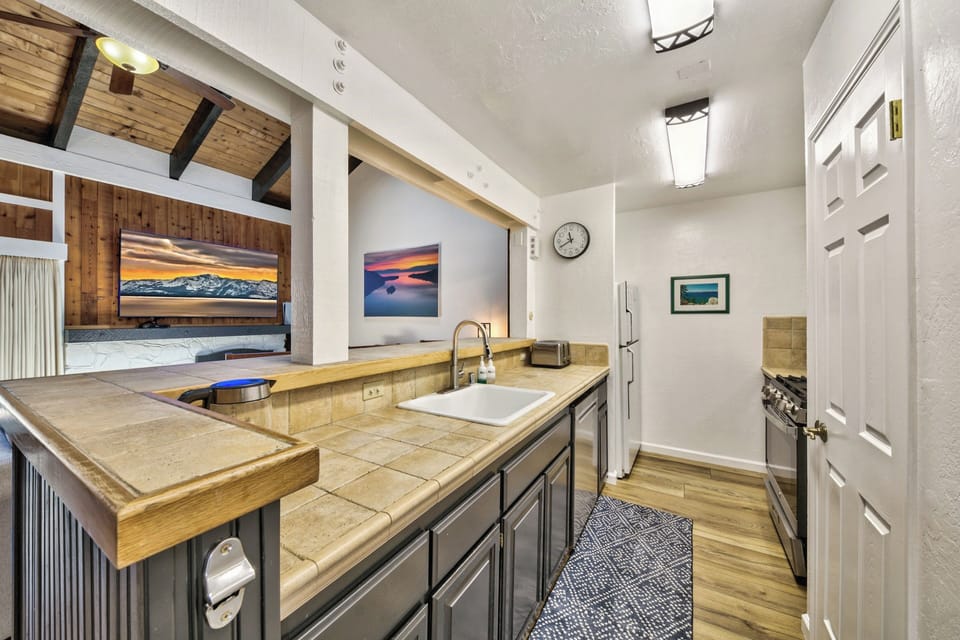 Your fully-equipped kitchen features warm tile counters, modern appliances, and an open layout perfect for creating memorable meals during your mountain getaway.