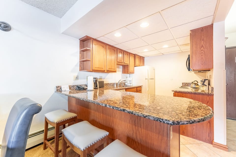 Your fully equipped kitchen features granite countertops, warm wood cabinetry, and stainless appliances—perfect for preparing memorable meals during your stay.