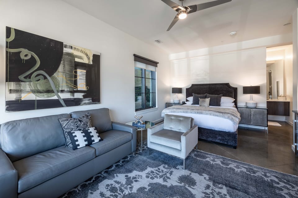 Suite style room features a spacious seating area, TV, and desk to work from home.