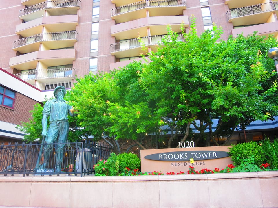 Exterior & facade of the iconic Brooks Tower with a historic Miner's sculpture 