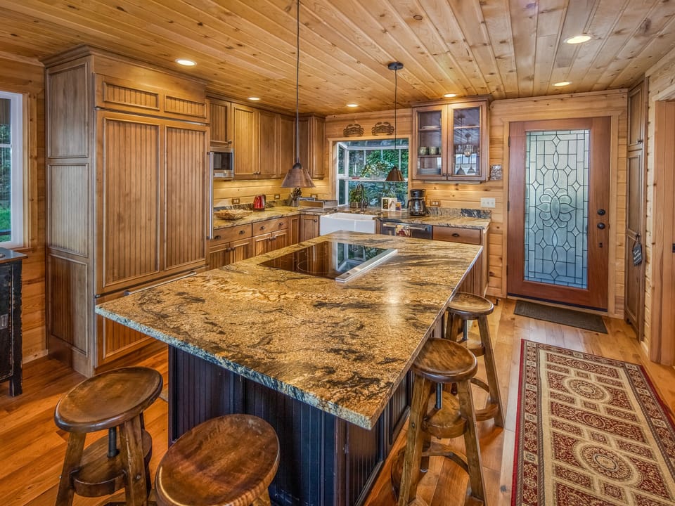 Kitchen with island and electric cook-top stove. Seating around the island for 6
