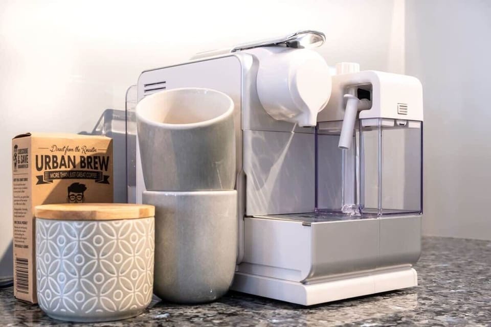 Coffee machine, milf frother, and pods are all provided.