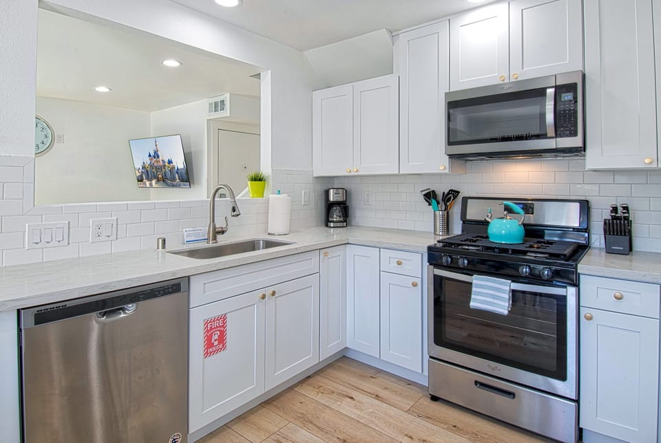 - Fully equipped kitchen with stainless steel appliances and essentials   - White cabinets and modern counters create a bright inviting space   - Perfect for cooking family meals during your vacation stay