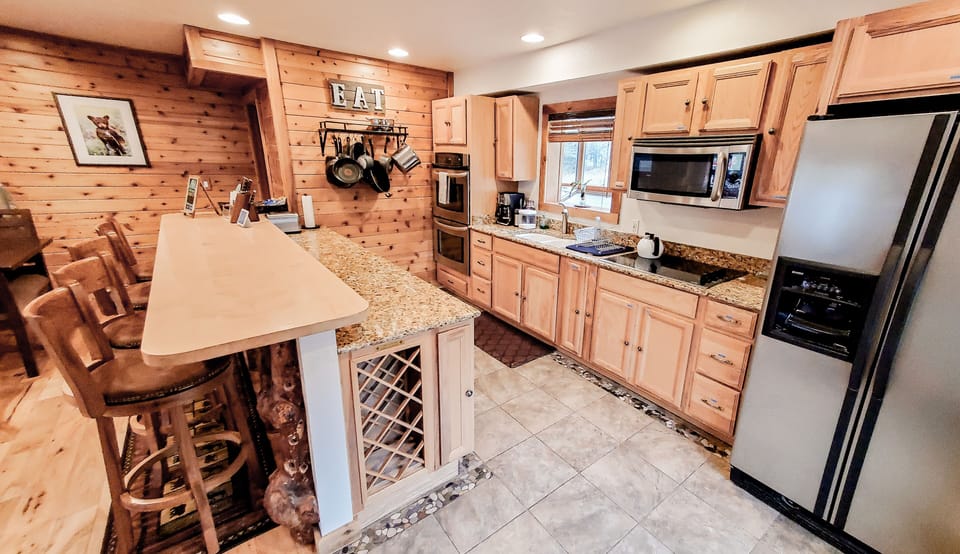 The main kitchen features granite counter tops, dual ovens, and a large fridge.