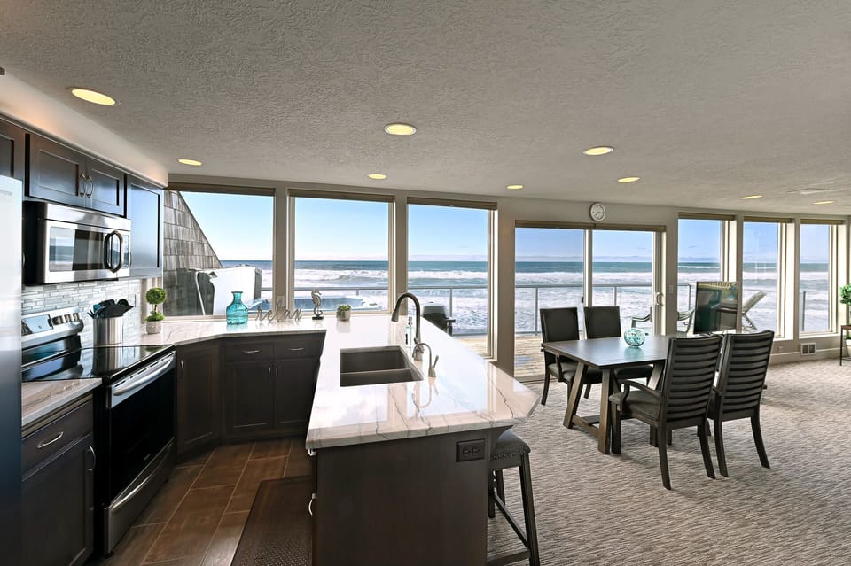 Open kitchen & dining space designed for easy meals w/ a view of the water.