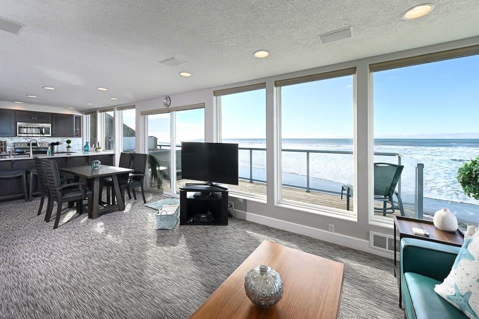 Exterior view of the home nestled right along the sandy beach.