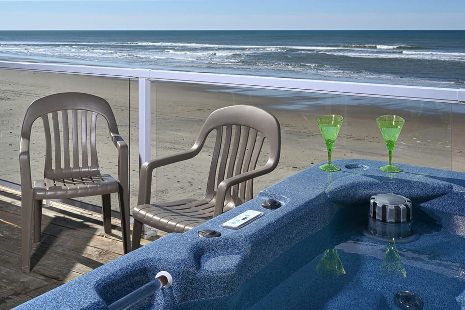 Oceanfront hot tub setup w/ seating, ideal for unwinding as waves roll in.