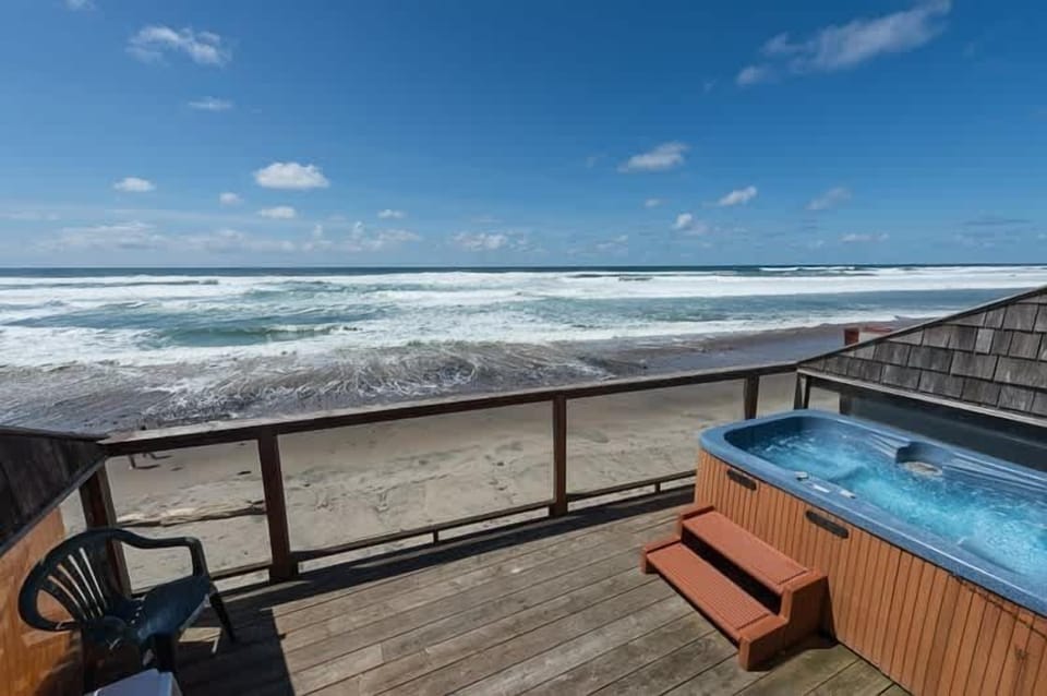 Oceanfront hot tub setup w/ seating, ideal for unwinding as waves roll in.