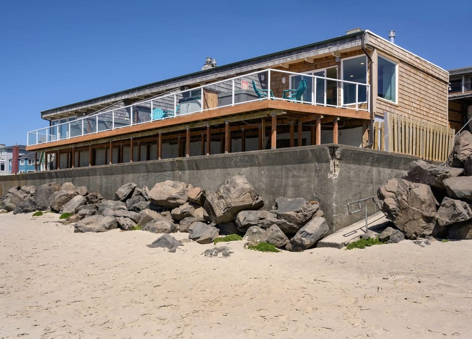 Elevated exterior view showcasing the home set above the shoreline.