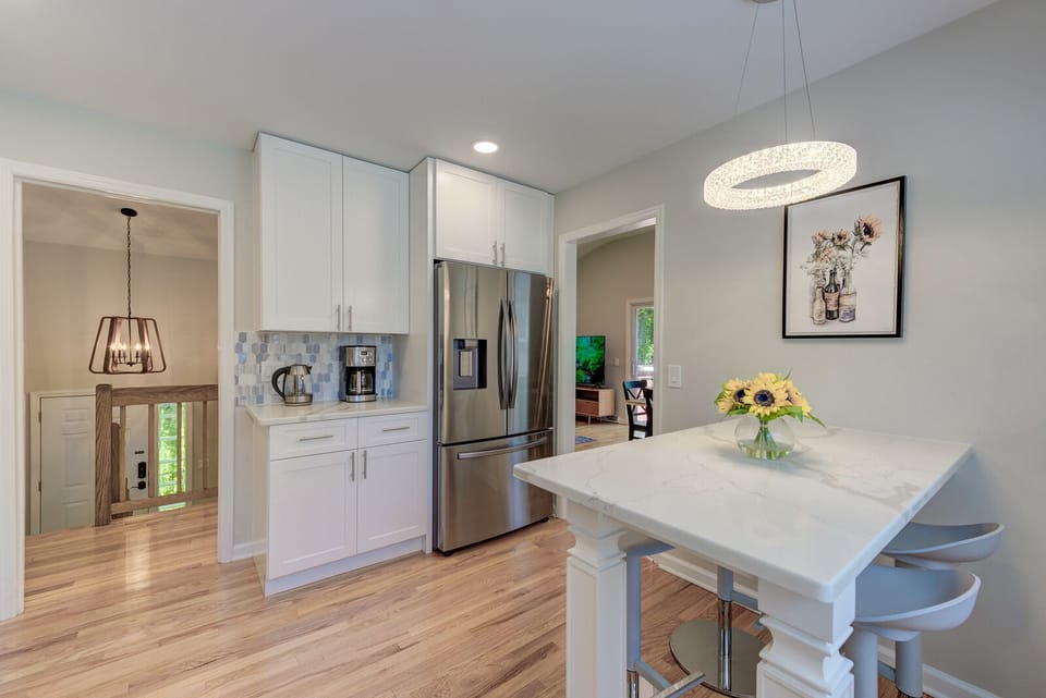 Kitchen with a stainless steel fridge, coffee maker, and tea kettle.