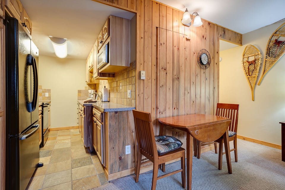 Your cozy mountain kitchen combines rustic pine walls with modern appliances, creating the perfect space for preparing memorable meals together.