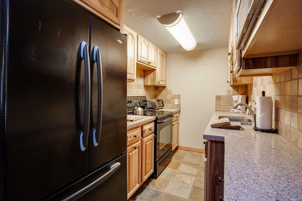 Prepare your favorite meals in this fully-equipped kitchen featuring granite countertops, stainless steel appliances, and all the essentials for your stay.