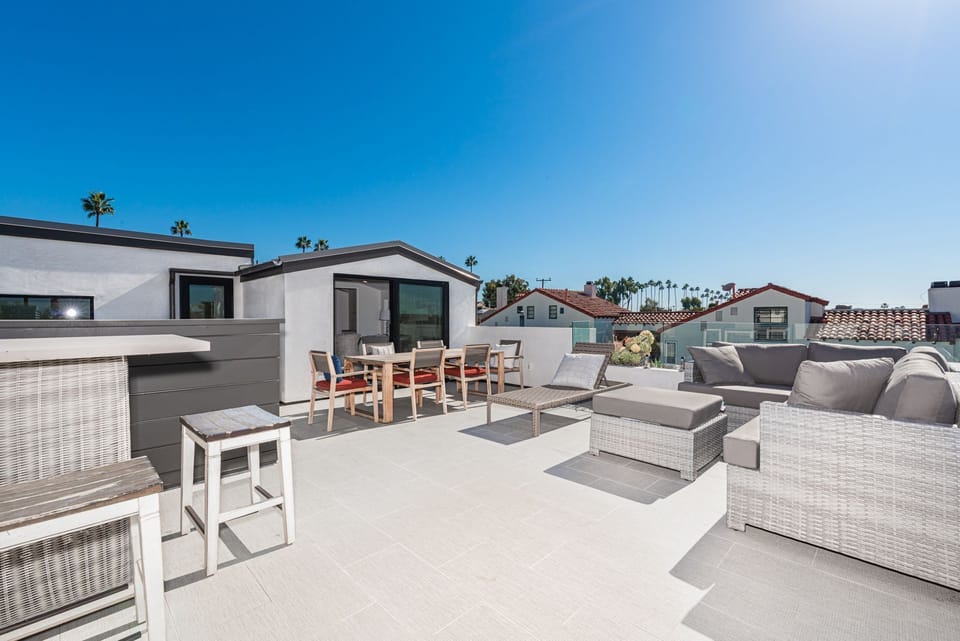The rooftop deck is expansive and looks out on the idyllic streets of Corona Del Mar and ocean beyond
                