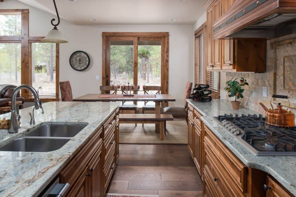 Kitchen directly leads to dining area and outdoor backyard patio with gas grill and outdoor seating.