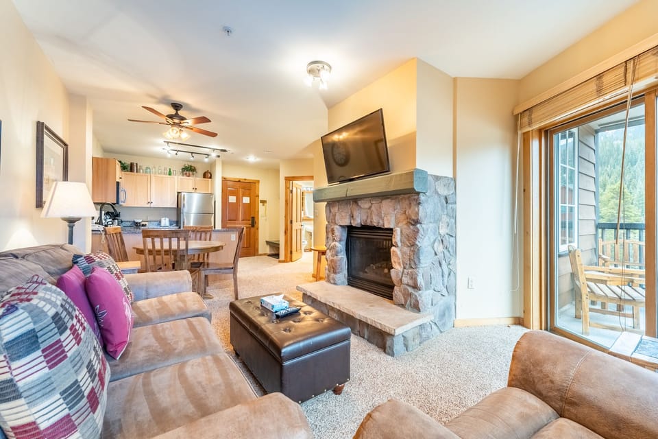 Cozy up by your stone fireplace while enjoying mountain views from your private balcony in this warm, well-appointed living space.