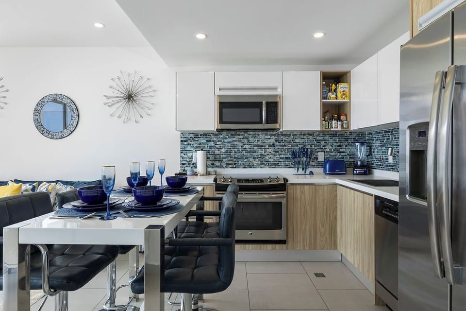 Your modern kitchen features sleek stainless steel appliances, a stylish mosaic backsplash, and a welcoming dining area perfect for sharing meals together.