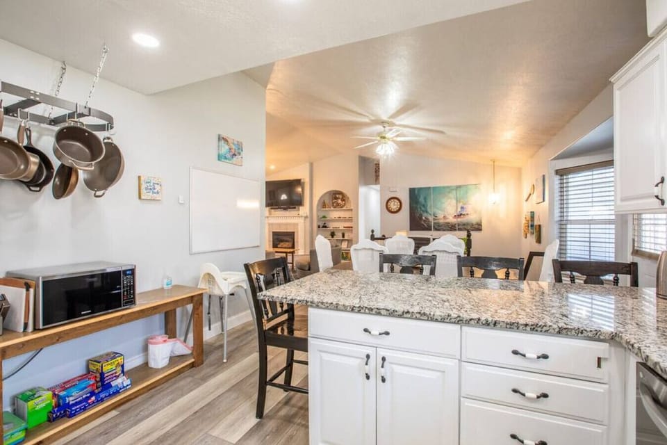 Fully stocked kitchen with hanging cookware and ample prep space.