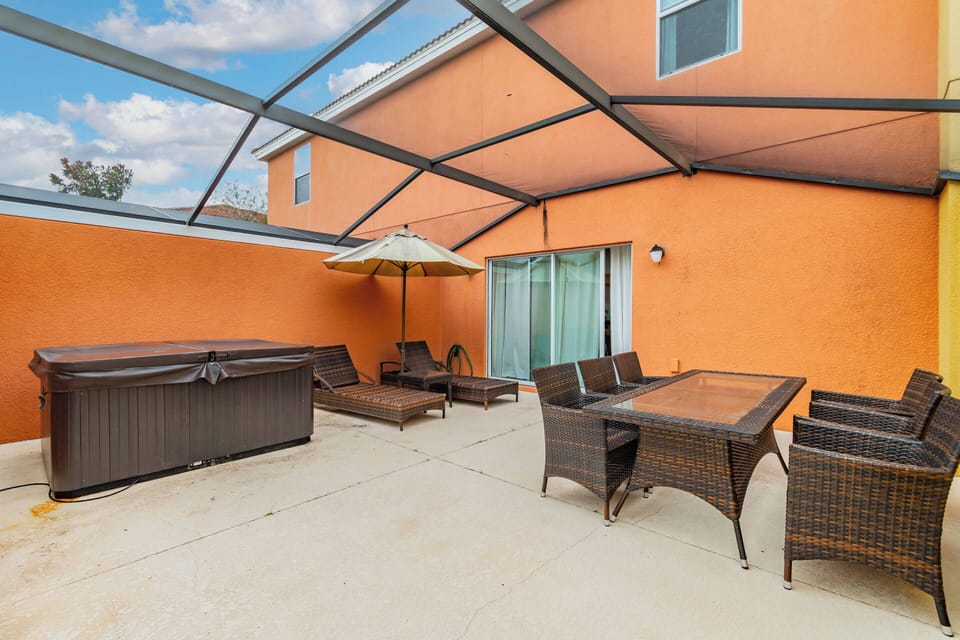 Step outside to your private oasis with a spacious patio, vibrant orange walls, and a sleek hot tub. Relax in comfortable wicker seating or enjoy al fresco meals at the stylish dining table, all designed for your enjoyment.