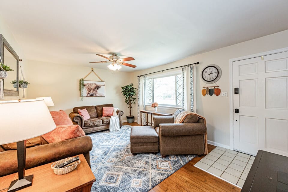 Bright & Cozy Retreat – Relax in a spacious, sunlit living room with stylish decor and ample seating for ultimate comfort. The addition of a large ceiling fan and Roku TV make for optimal unwinding.