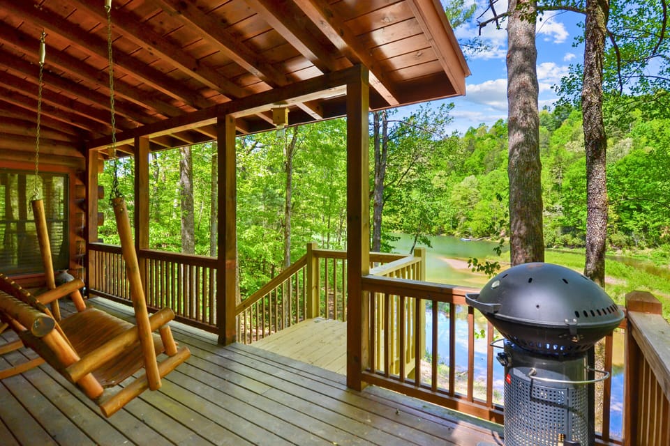 Custom log furniture overlooking the lake underneath the covered patio.