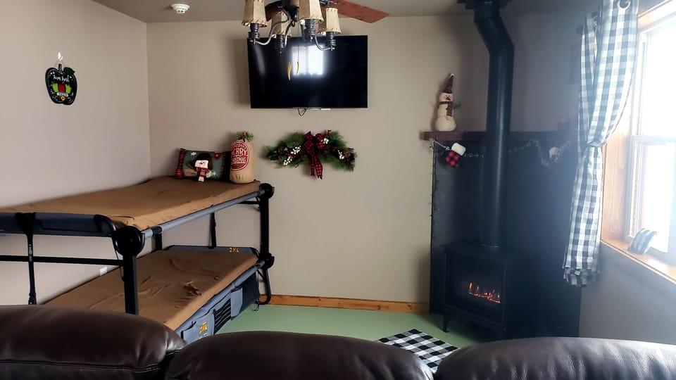 Livingroom has Bunks, Gas Fireplace a Smart TV and a leather recliner sofa.