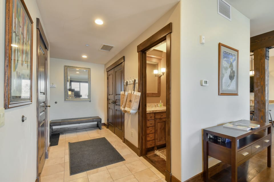 Entryway into apartment with powder room and closet space.