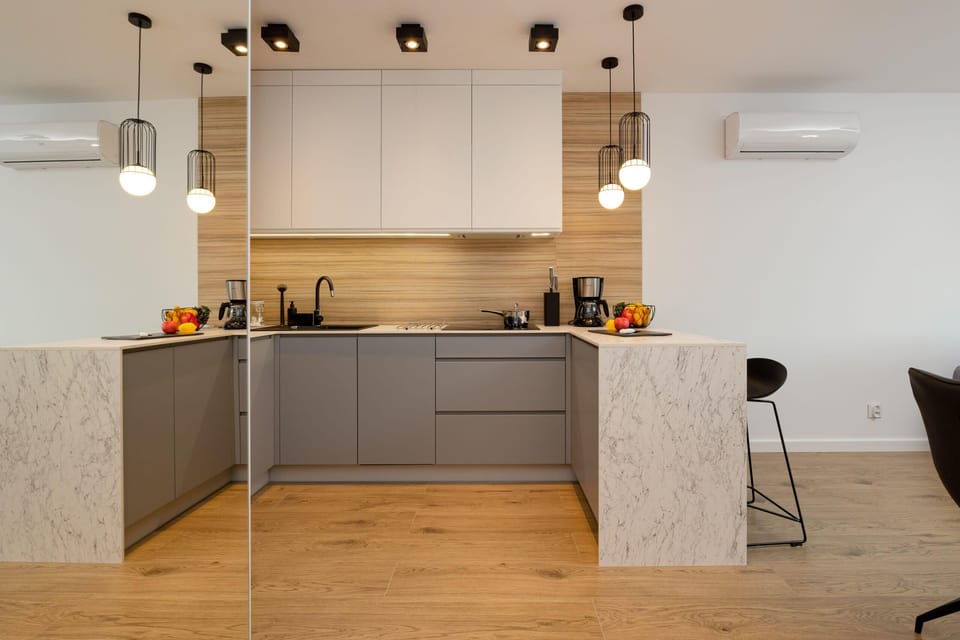 A kitchenette with modern furniture that accommodates all the necessary accessories for preparing home-cooked meals.