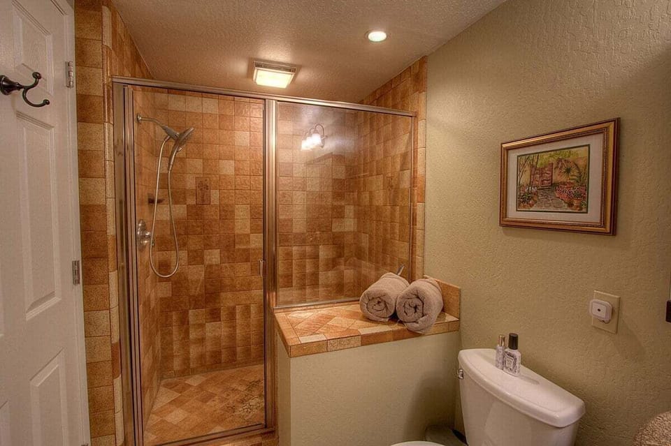 Bathroom with a walk-in shower and a half-wall ledge.