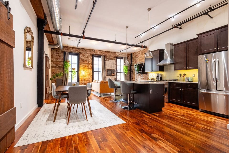 Open-concept kitchen with stainless appliances, island seating, and warm natural light.