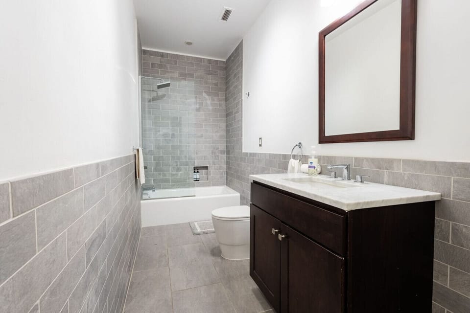 Spacious bathroom featuring a full tub/shower combo and contemporary finishes.