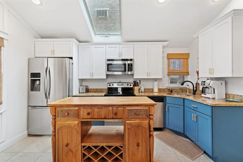 This kitchen boasts a wooden island, granite countertops, and modern stainless steel appliances.